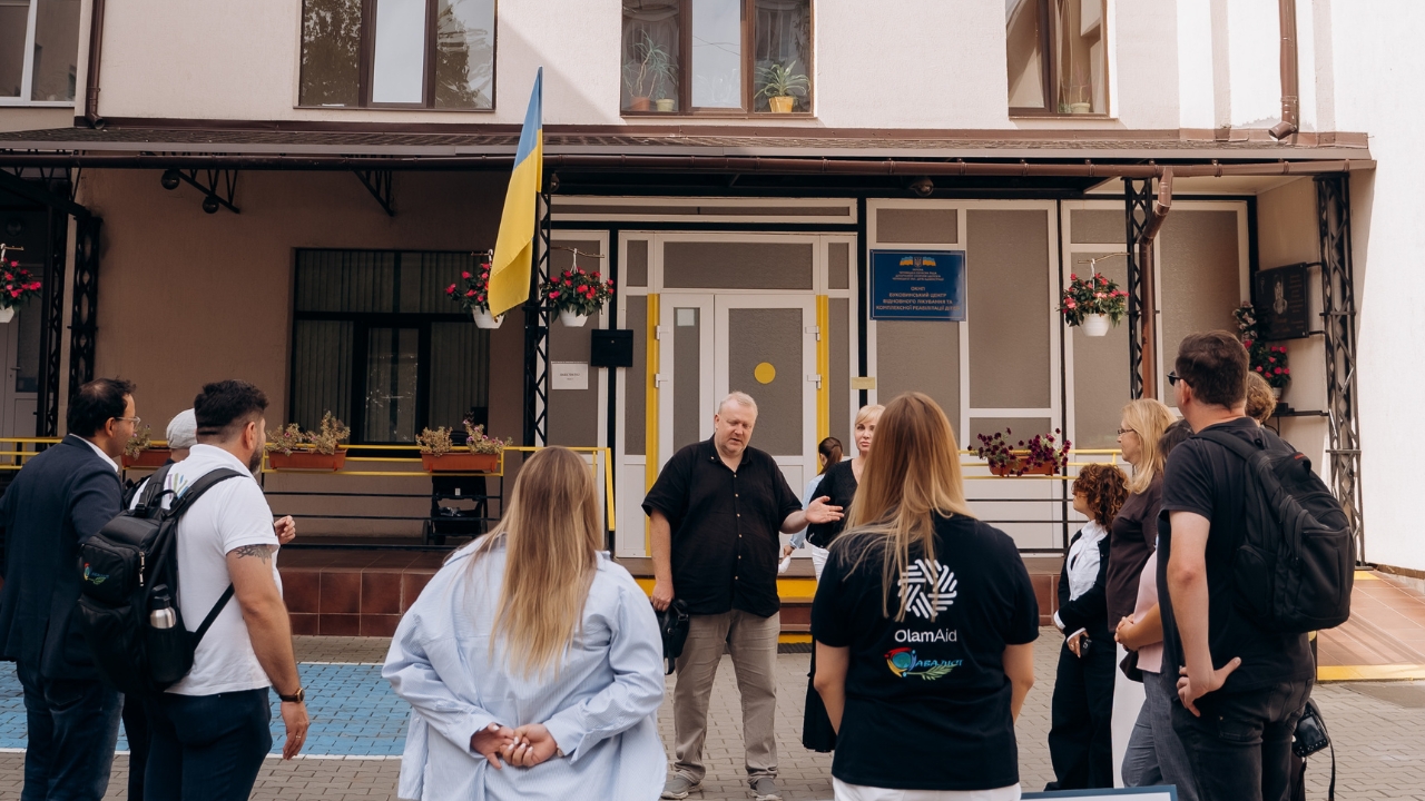 Gruppe Menschen vor einem Gebäude mit Ukraine Flagge
