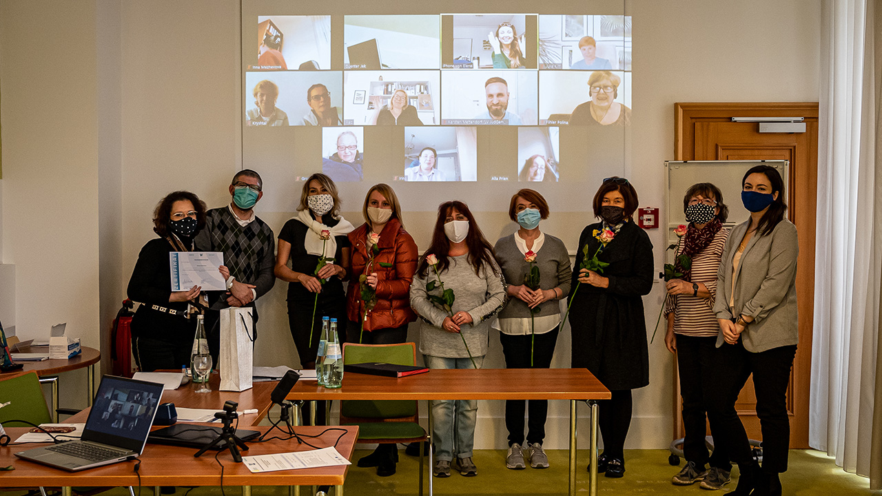 Seminarteilnehmende mit Maske und Zoom-Teilnehmende