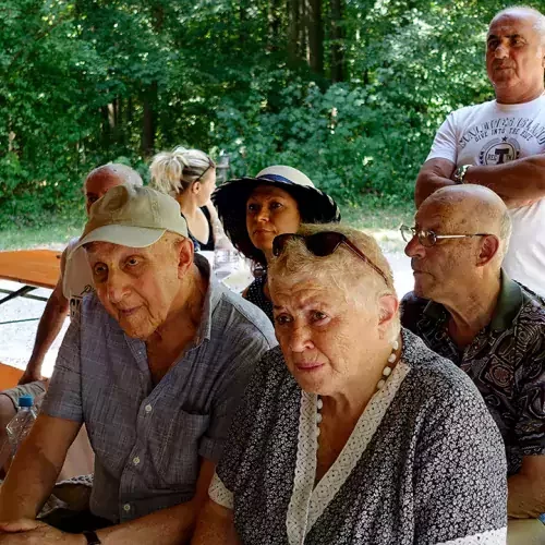 Eine Gruppe von Senioren und Seniorinnen sitzt auf einer Bank