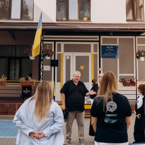 Gruppe Menschen vor einem Gebäude mit Ukraine Flagge