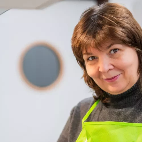 Frau mit Schürze lächelt in die Kamera