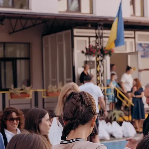 Menschen vor einem Gebäude mit einer ukrainischen Farbe