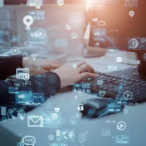 Mensch tippt auf Tastatur vor einem PC