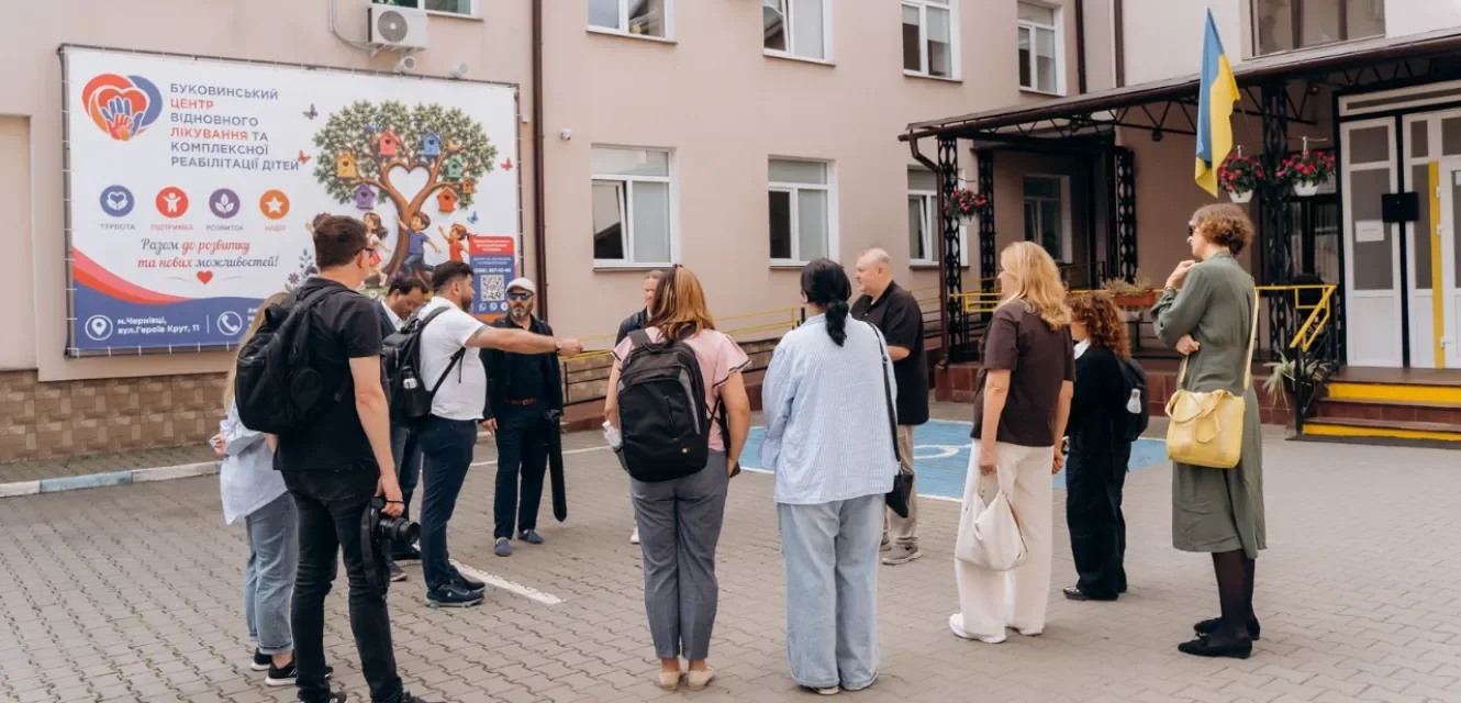 Ein kleiner Kreis von Menschen vor einem Krankenhaus