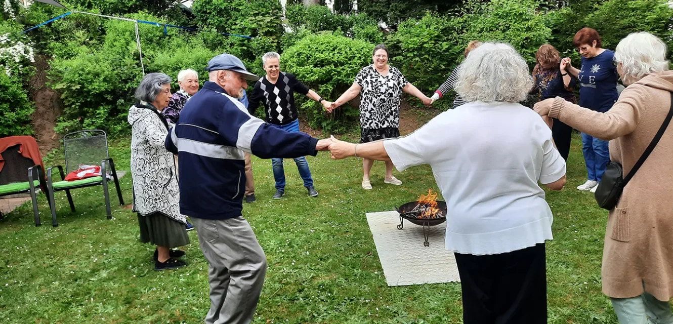 Ältere Menschen tanzen im Kreis