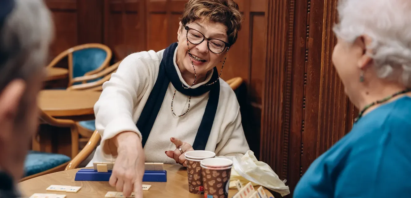 Ältere Dame freut sich beim Gesellschaftsspiel