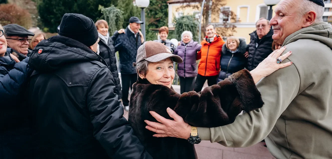 Gruppe von Senioren, eine Frau lächelt in die Kamera