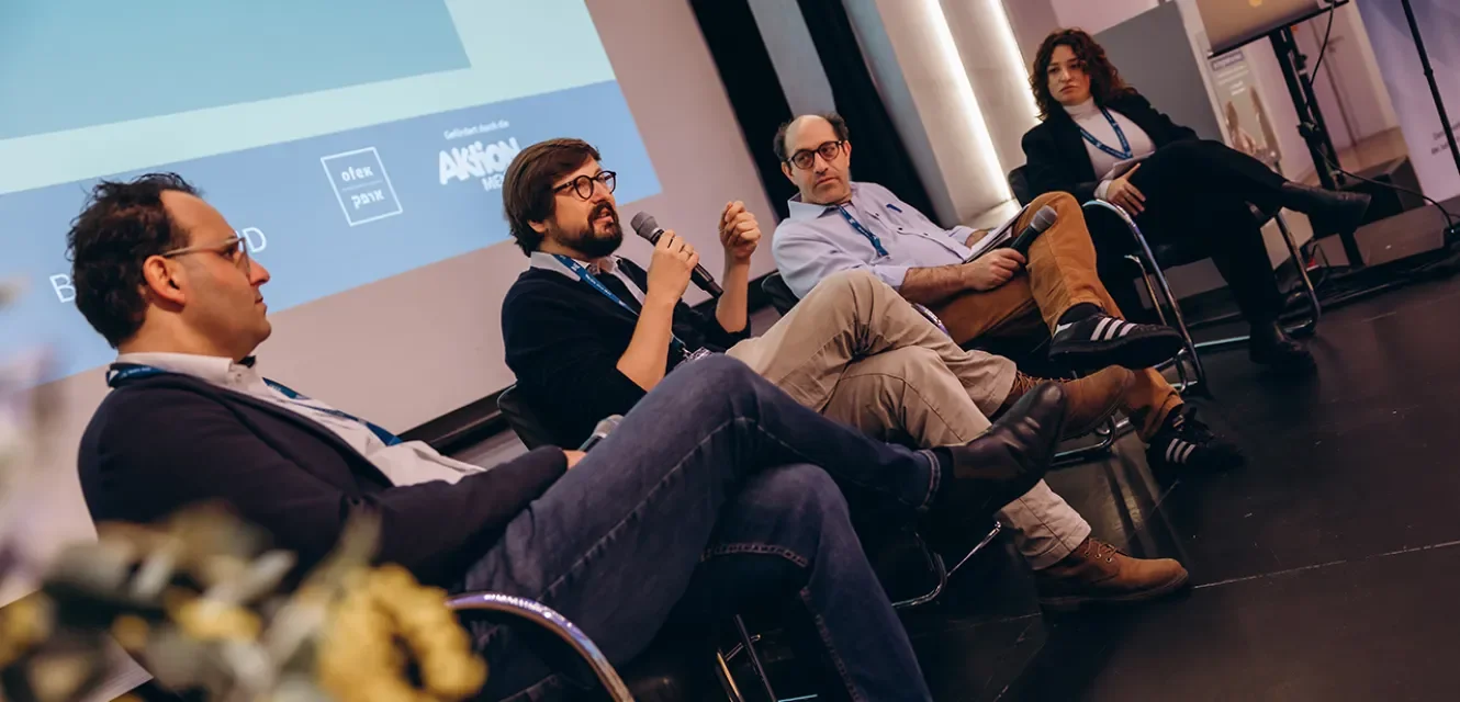 Menschen diskutieren auf einem Podium 