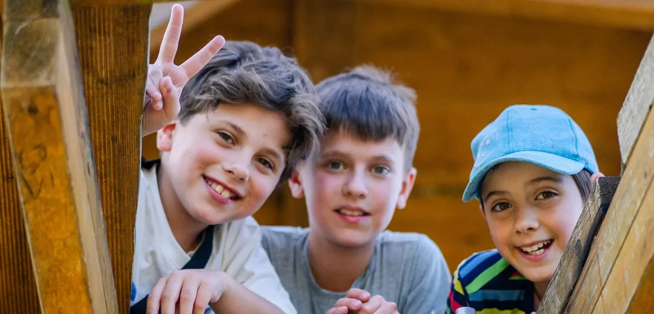 Drei Jungs lächeln von oben in die Kamera 