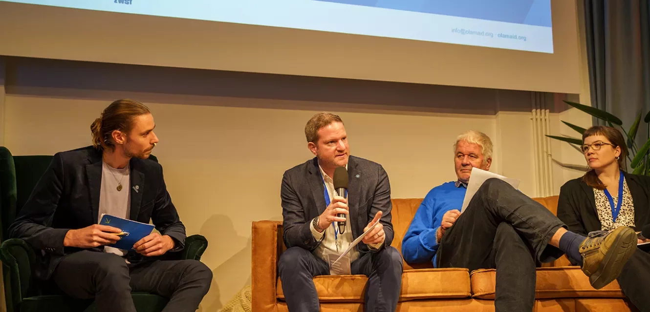 vier Menschen sprechen auf dem Podium  