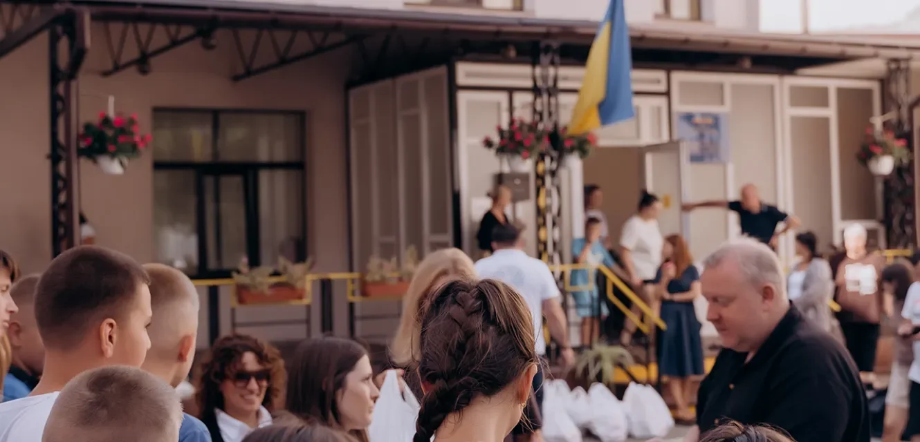 Menschen vor einem Gebäude mit einer ukrainischen Farbe
