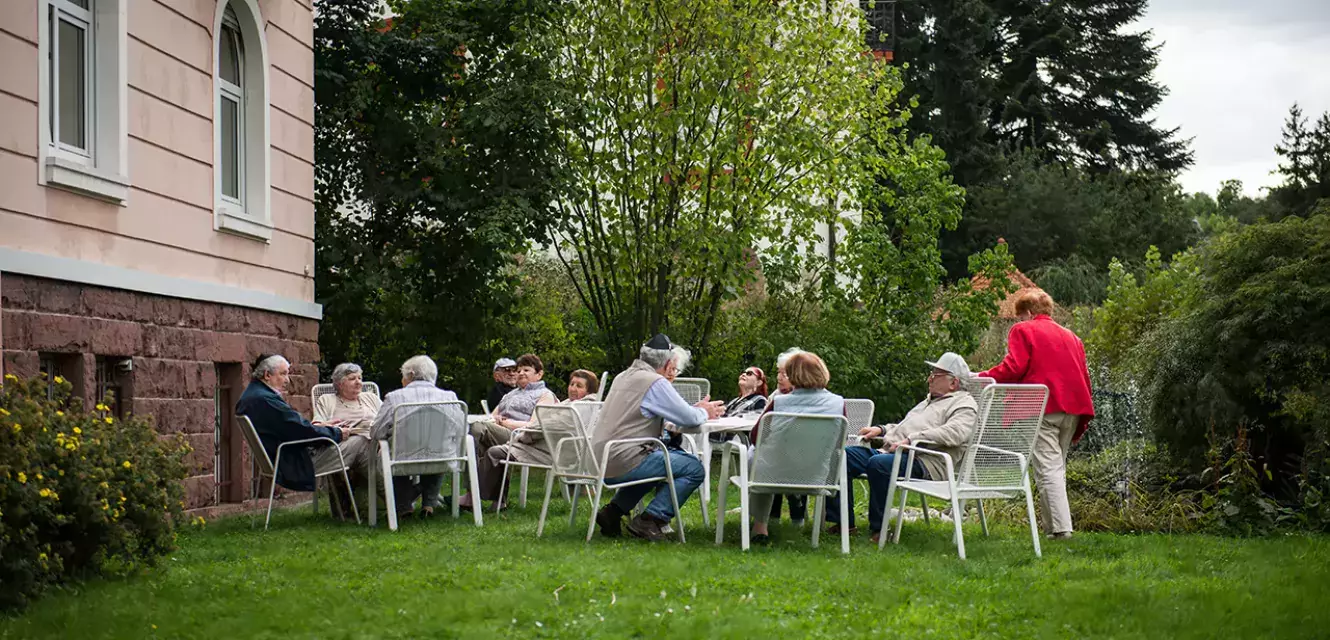 Senioren sitzen im Garten des Kurheim Beni Bloch