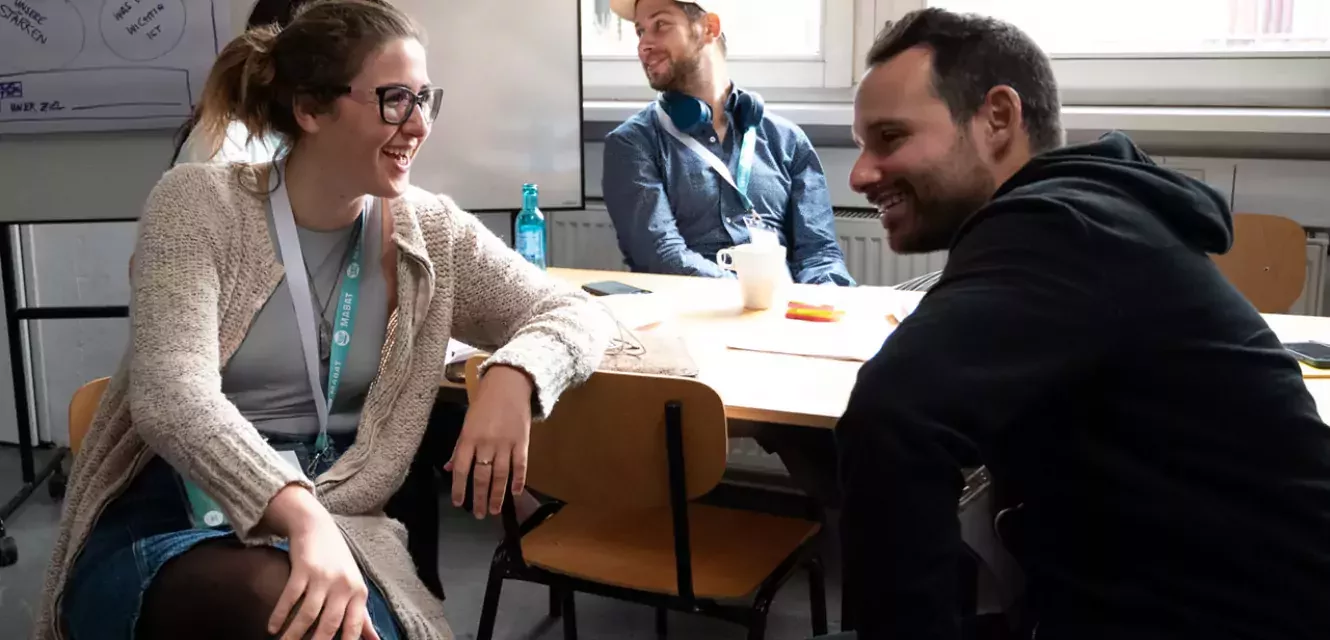 Frau und Mann unterhalten sich an einem Tisch