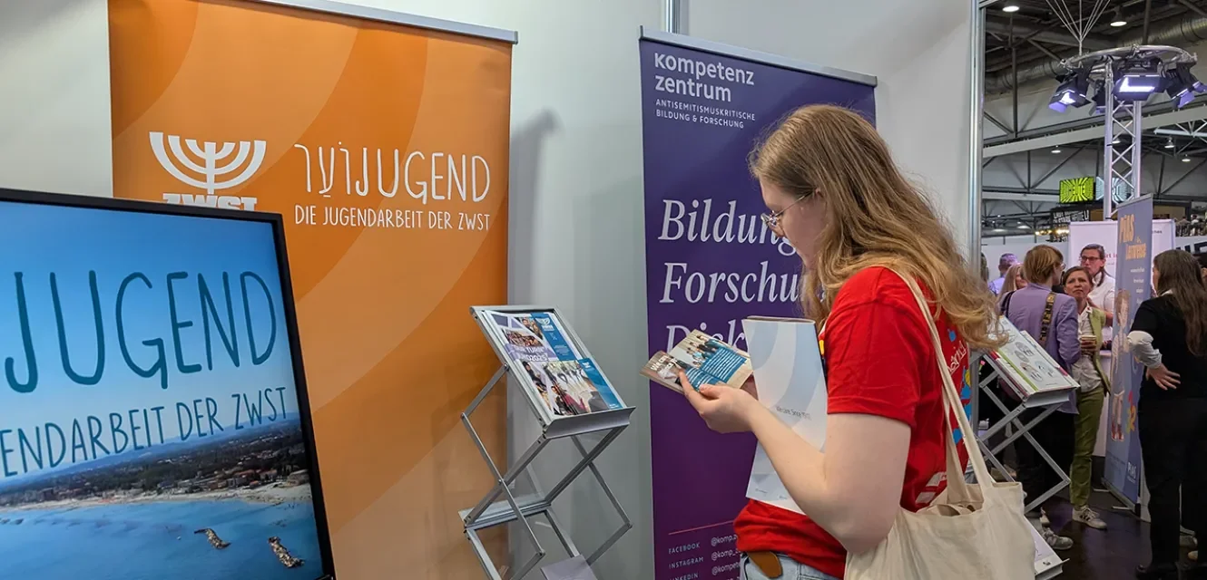 Eine junge Frau informiert sich am Stand der ZWST