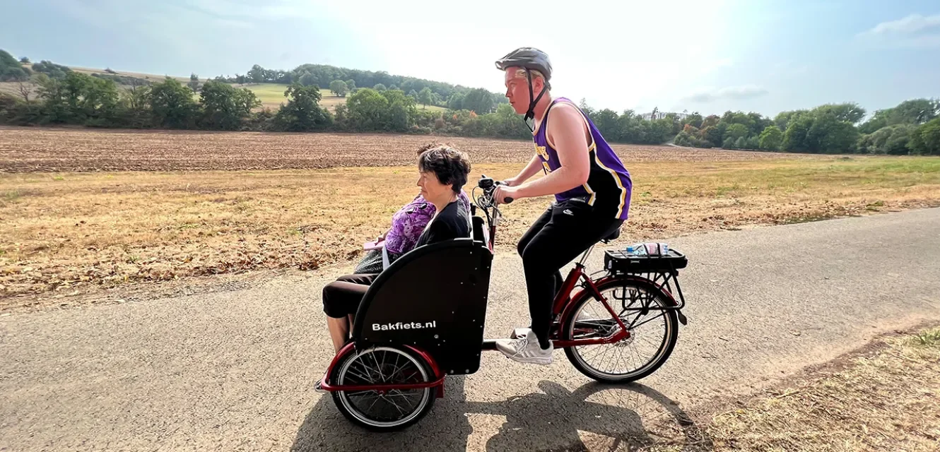 Ein Mann fährt zwei Frauen in einem Lastenrad