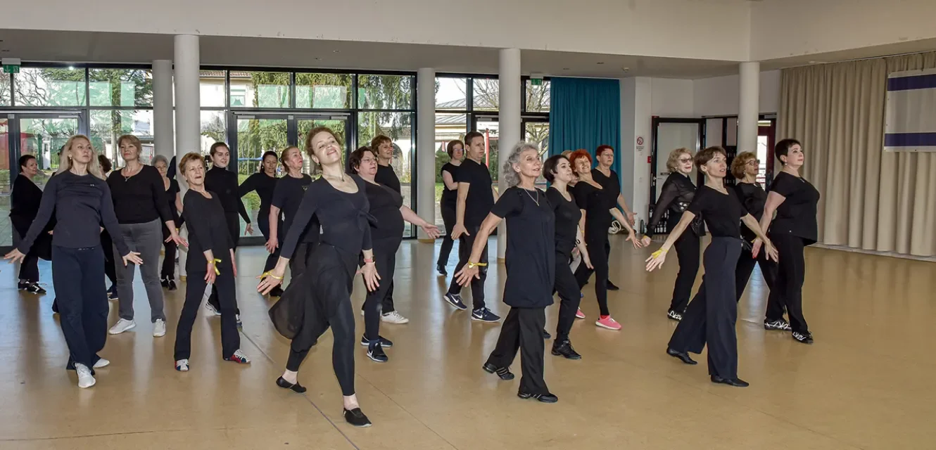 Eine große Gruppe von Menschen tanzt eine Choreografie