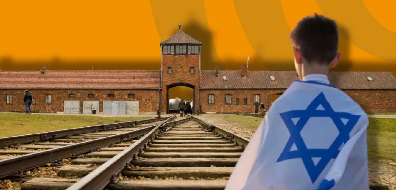 Junge mit Israelfahne steht vor Auschwitz