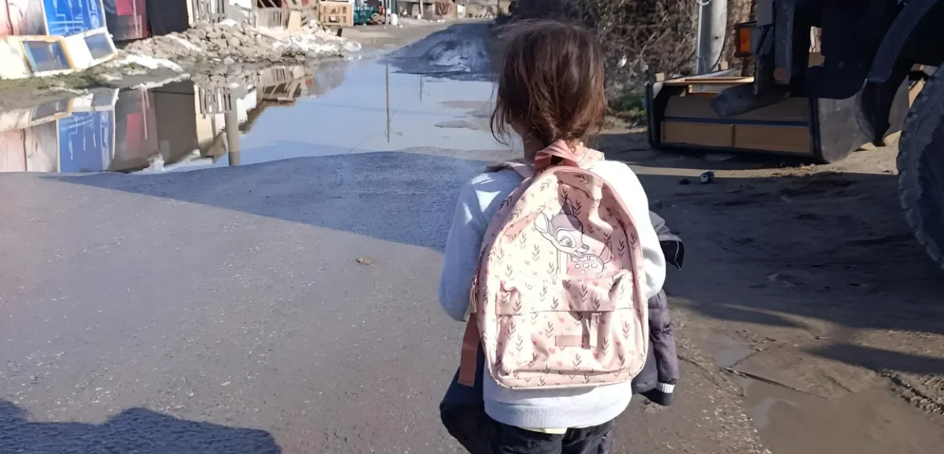 Ein Mädchen mit Rucksack läuft eine Straße entlang