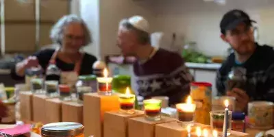 Atmosphärisches Bild mit Kerzen und Menschen im Hintergrund
