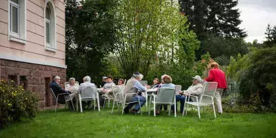 Senioren sitzen im Garten des Kurheim Beni Bloch
