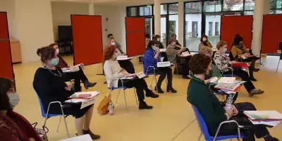 Seminarteilnehmende mit Maske bei einem Vortrag