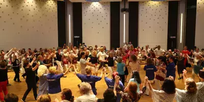 Viele tanzende Menschen in einem großen Saal