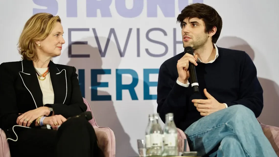 Zwei Menschen auf einem Podium im Gespräch
