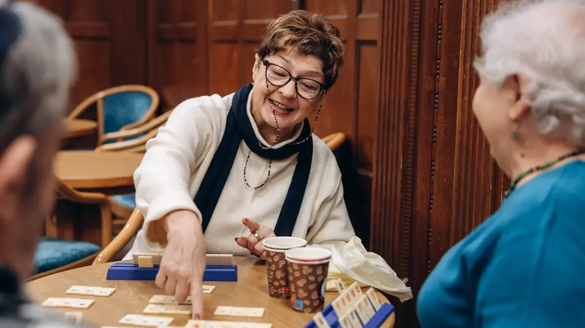 Ältere Dame freut sich beim Gesellschaftsspiel