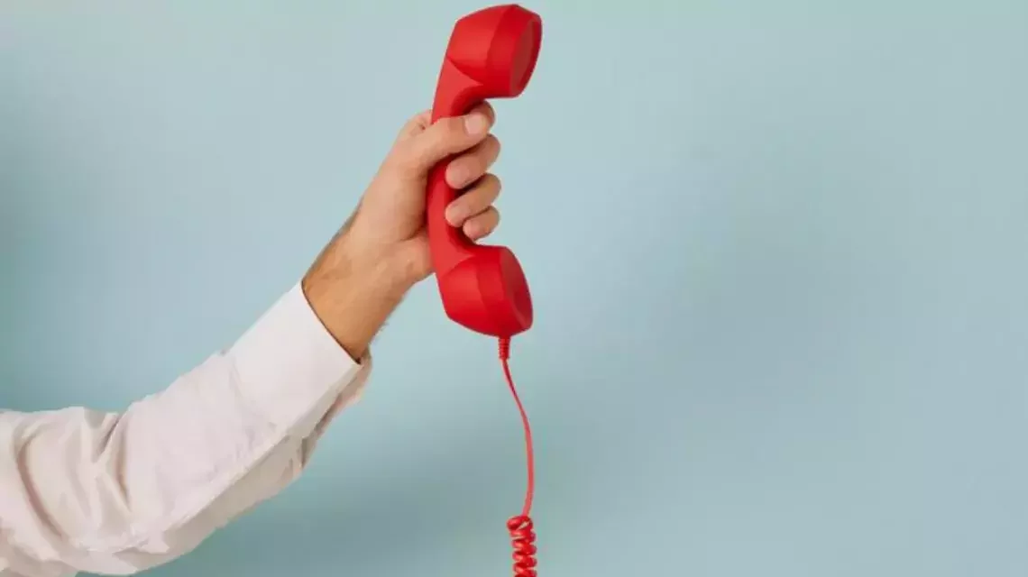 Rotes Telefon in einer Hand