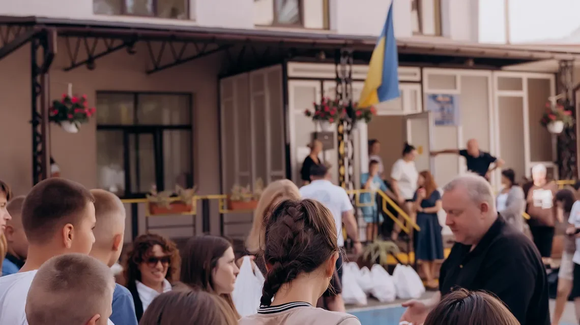 Menschen vor einem Gebäude mit einer ukrainischen Farbe