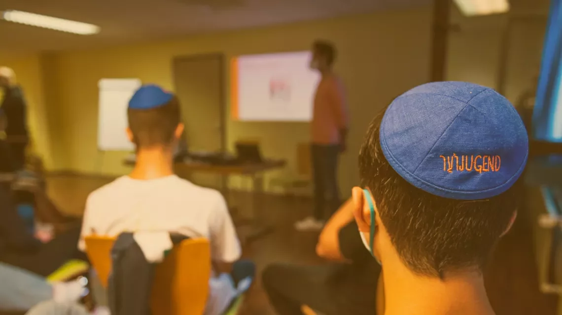 Ein Kopf eines Jugendlichen mit einer beschrifteten Kippa