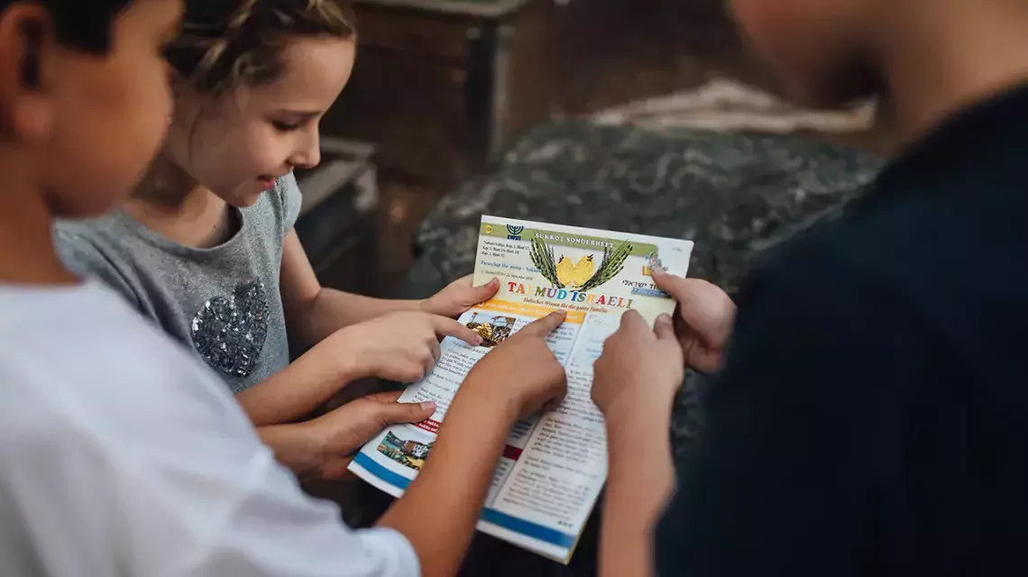 Kinder betrachten gemeinsam eine Zeitung