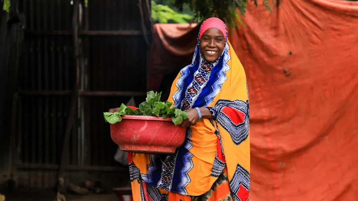 Eine Frau mit Gemüse lächelt