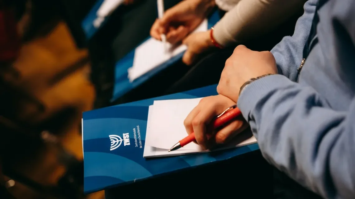 Seminarsituation, Hände mit Stiften und Arbeitsmappen