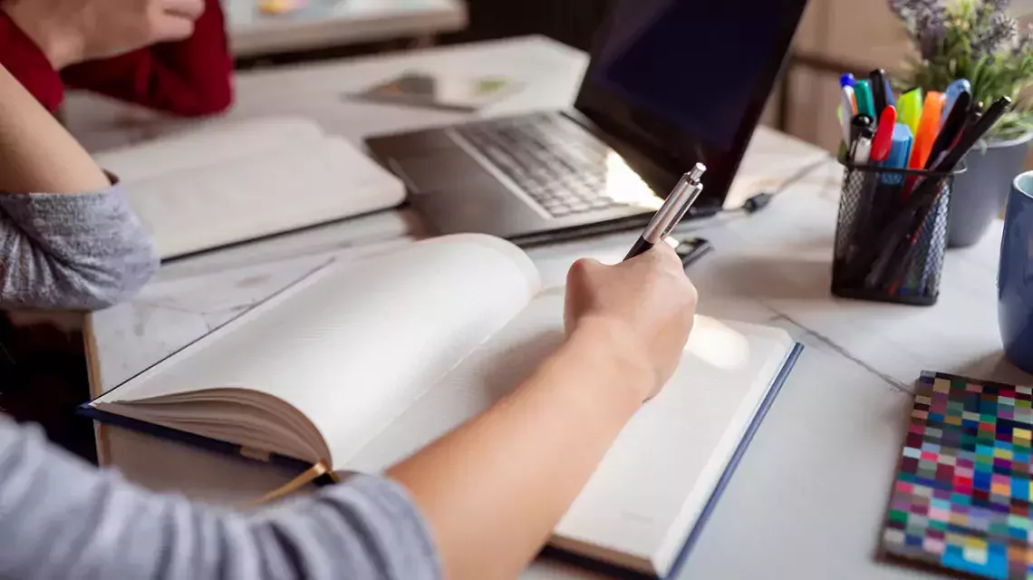 Eine Person macht sich Notizen in einem Notizblock