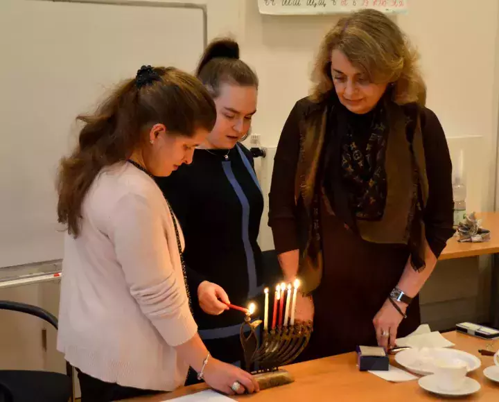 Eine Familie zündet Chanukka Kerzen an